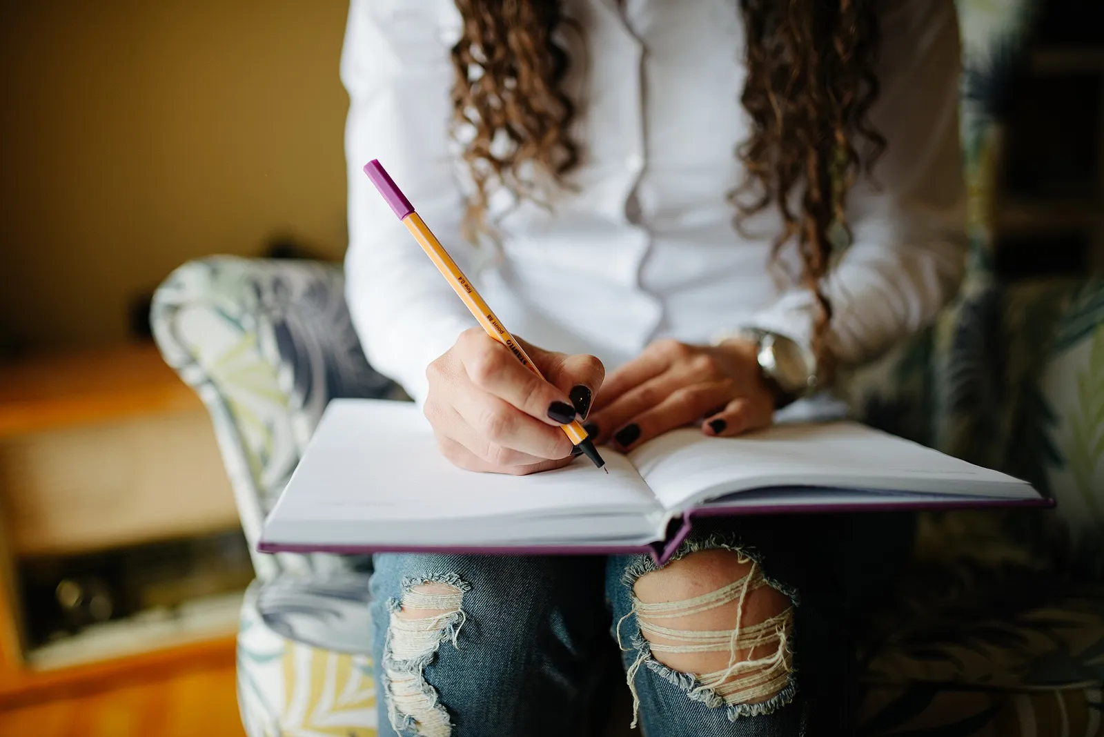 Tangan menulis catatan di buku agenda