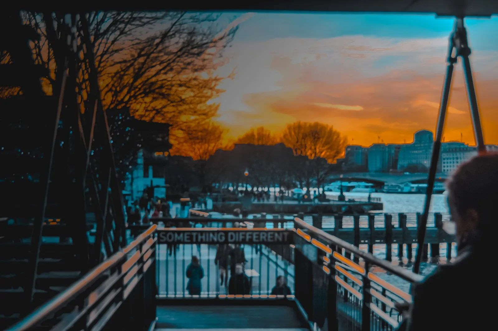 Foto jalan saat matahari terbenam dengan warna oranye dan biru yang kuat